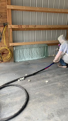 A professional spray foam installer at work, applying insulation to a building assembly — a real-world demonstration of spray foam performance.